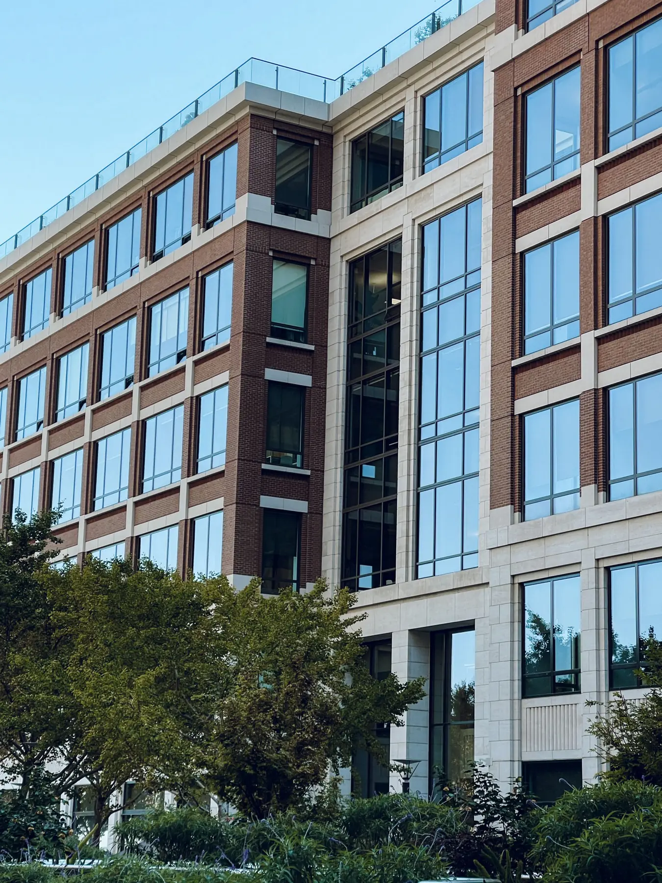 Brick and glass commercial office building surrounded by trees